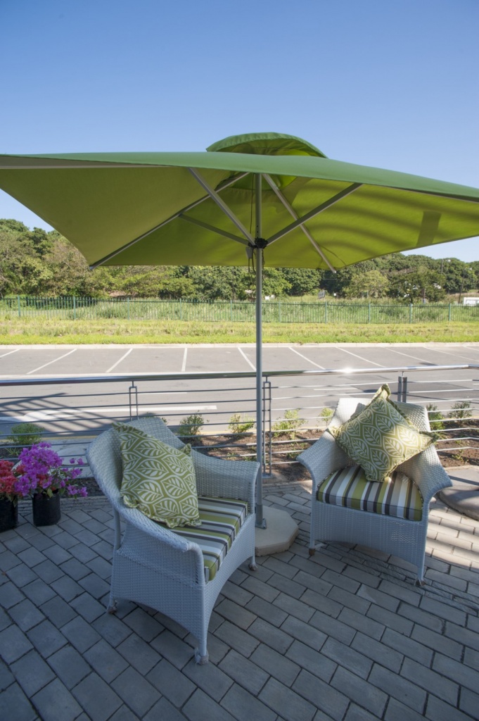 Makuti armchairs with stripped green cushions.