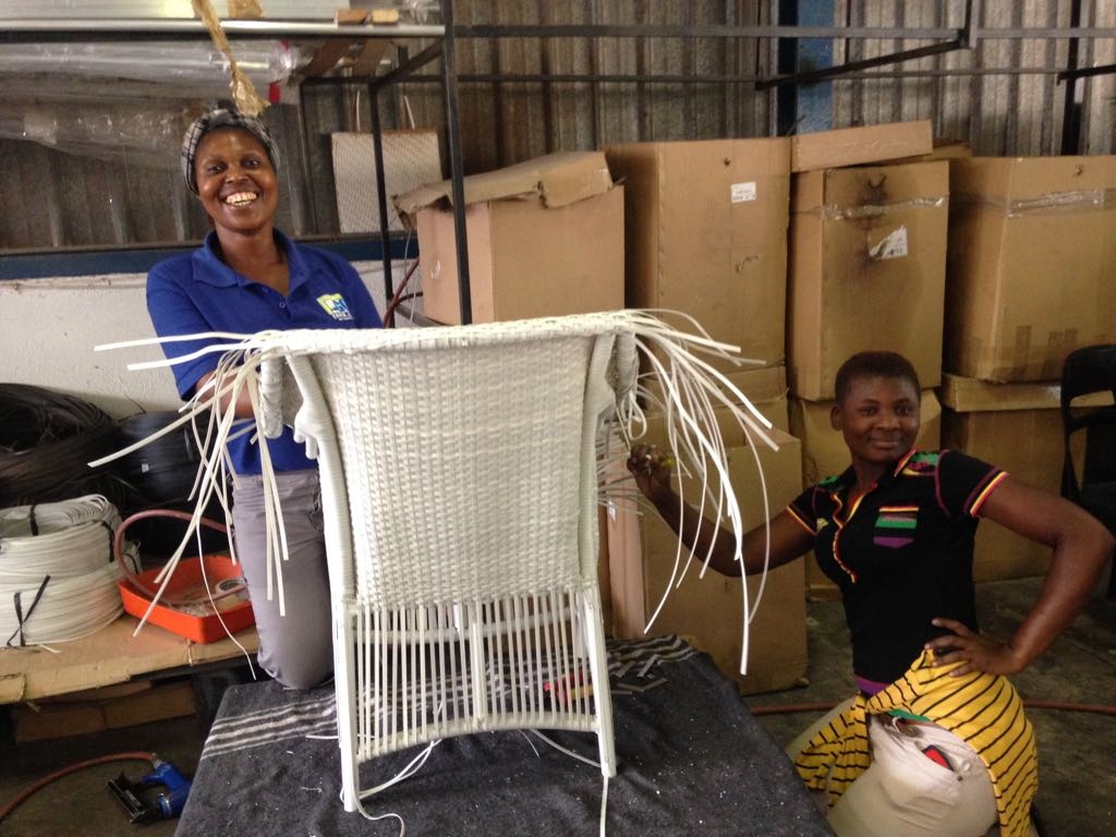 Two happy ladies weaving the Makuti armchair.
